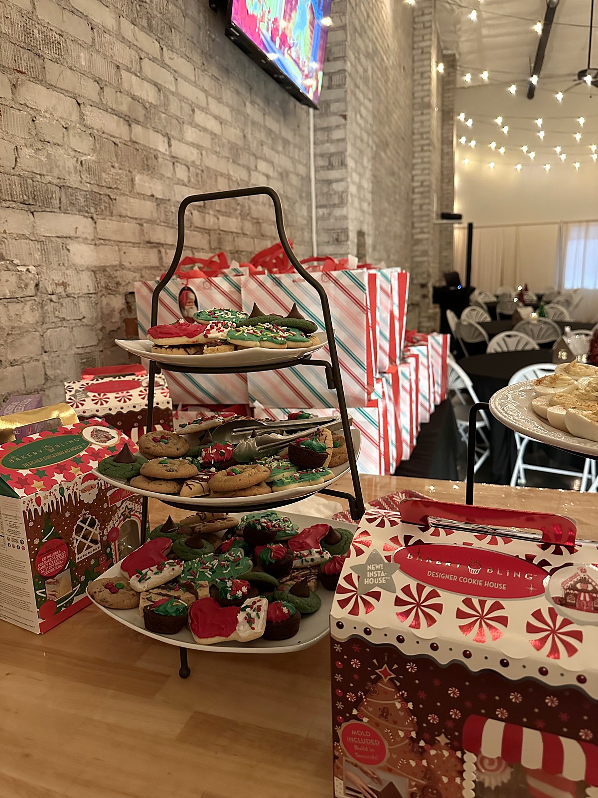 Christmas cookie decorating station with decorated cookies on tiered trays
