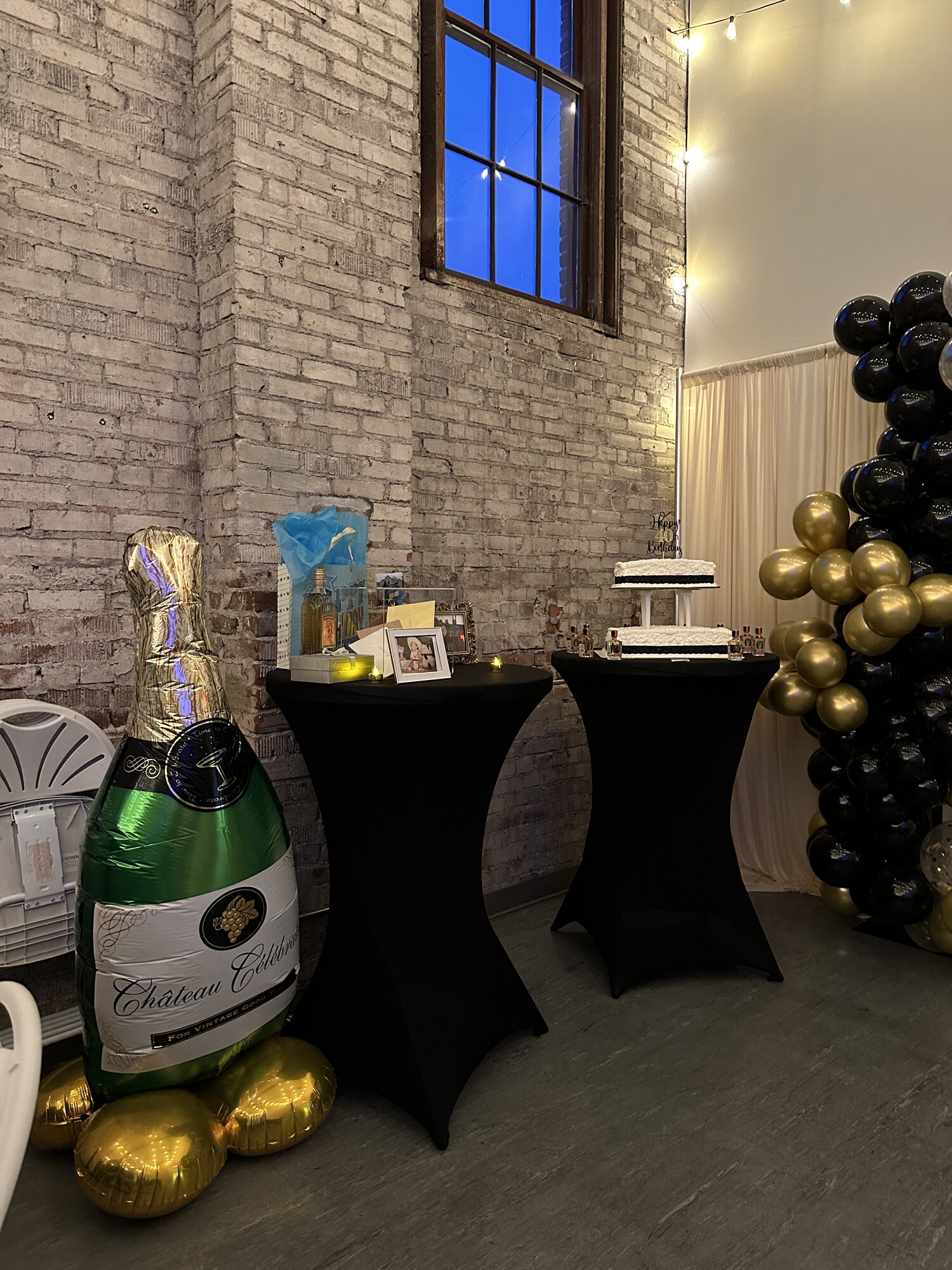 Giant champagne bottle balloon, gift table and cake table at a 40th birthday party in downtown Wenatchee