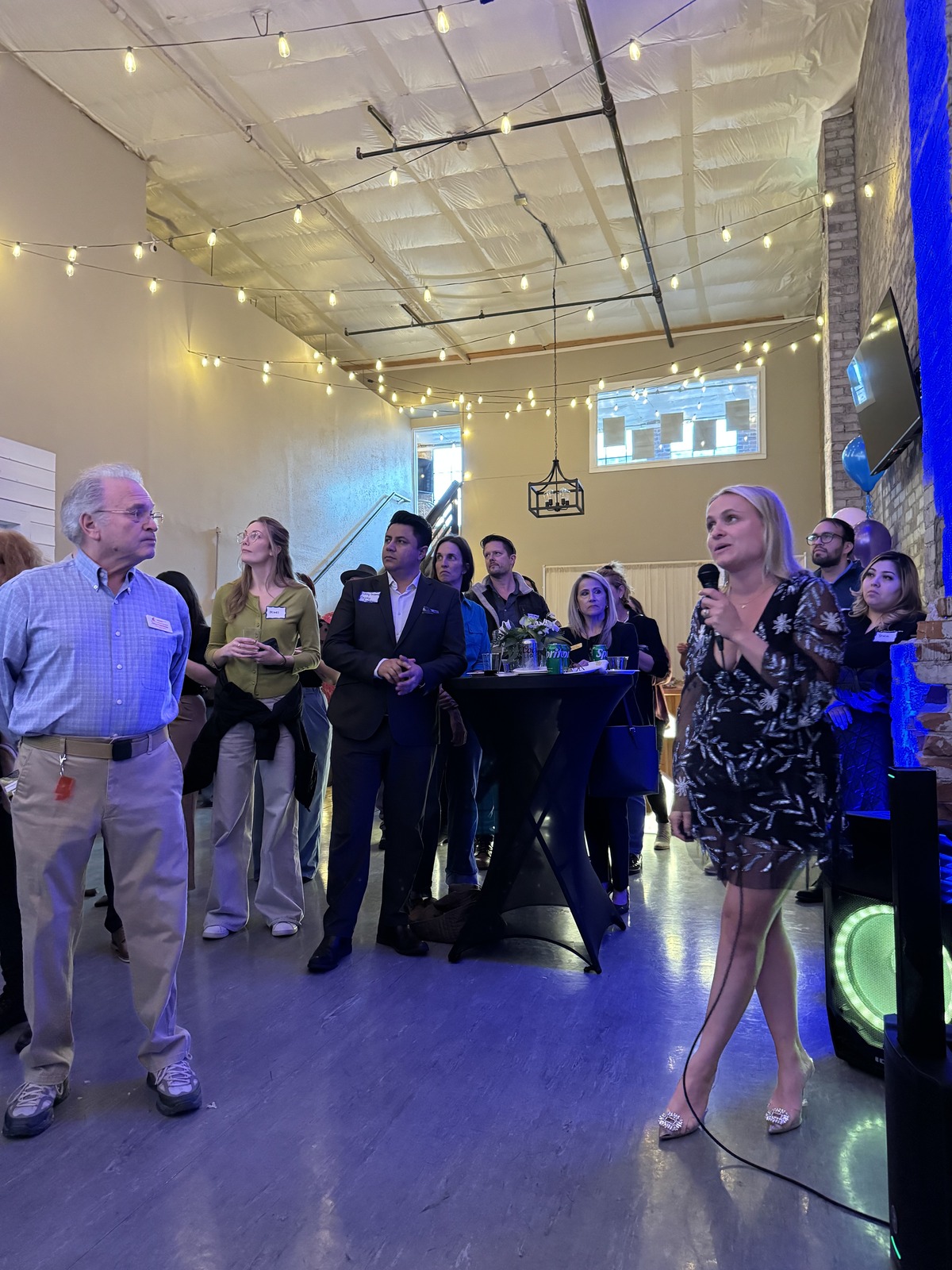 Speaker with a microphone addressing guests at a corporate networking event in downtown Wenatchee