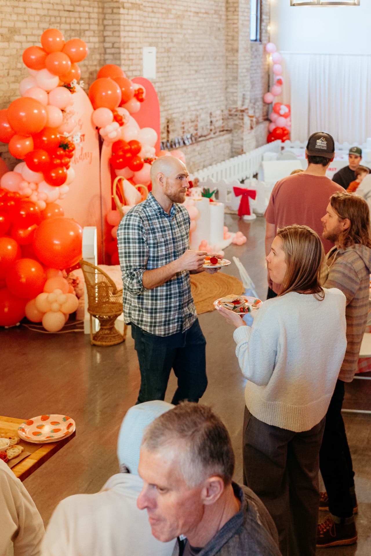 Guests mingling with plates beside the balloon backdrop at Host Wenatchee