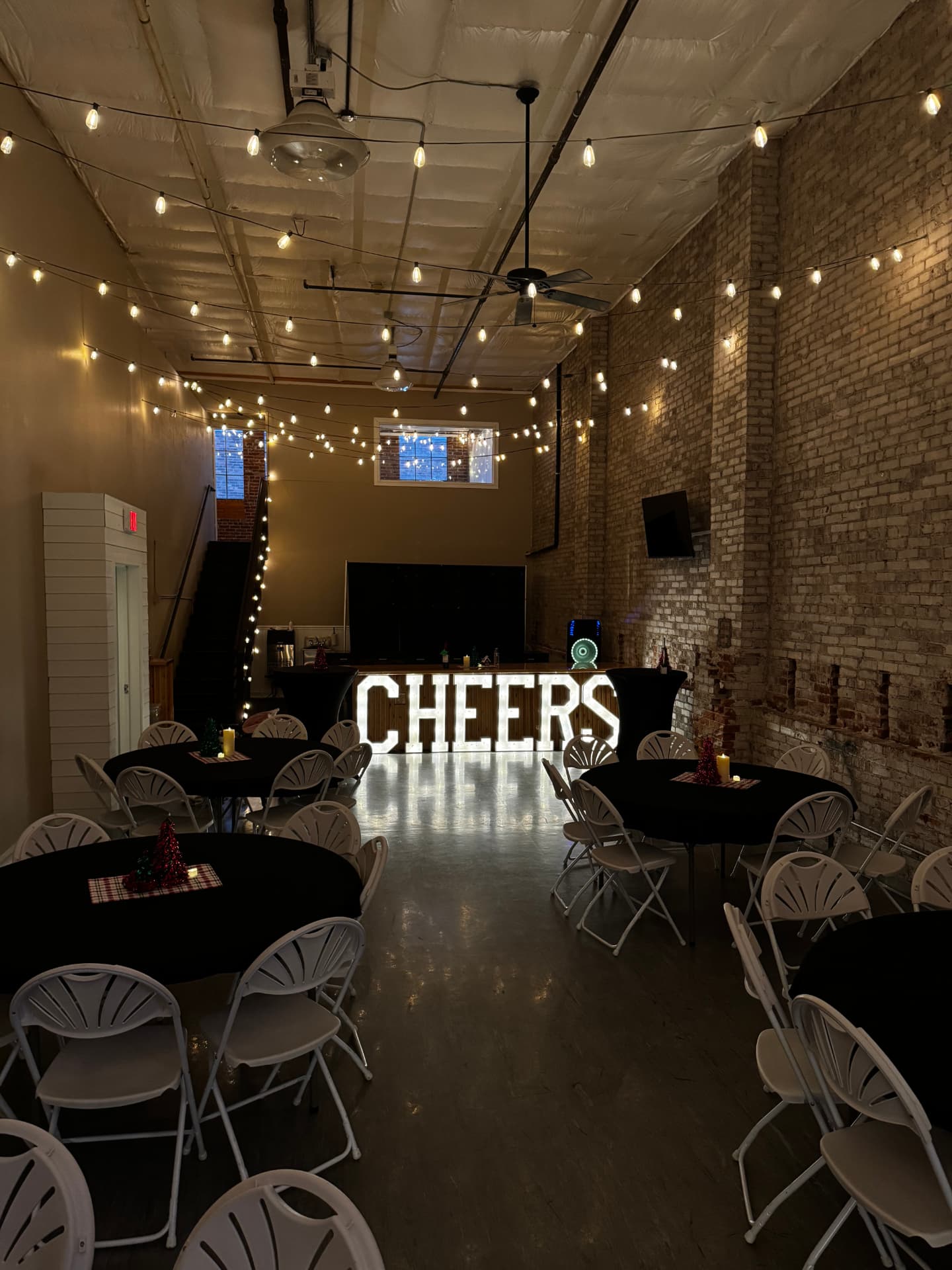 Light-up CHEERS marquee letters and mini Christmas tree centerpieces at a holiday party at Host Wenatchee