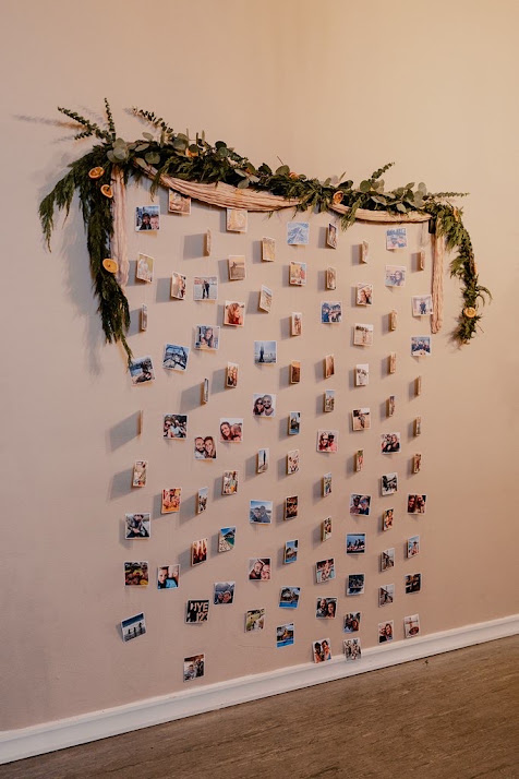 Hanging photo display wall with eucalyptus garland at a Host Wenatchee wedding