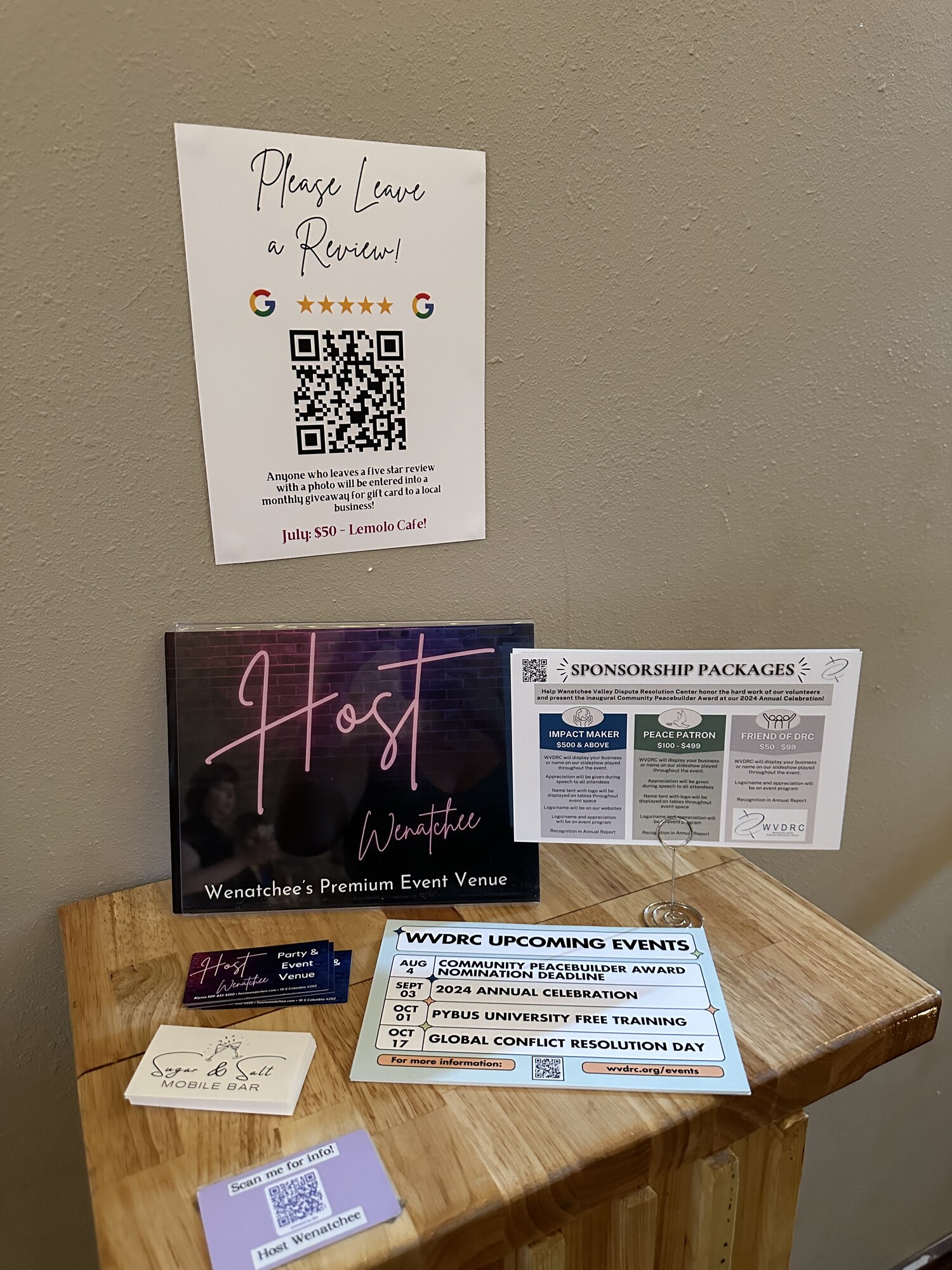 Welcome table with sponsorship packages, business cards and event signage at Host Wenatchee