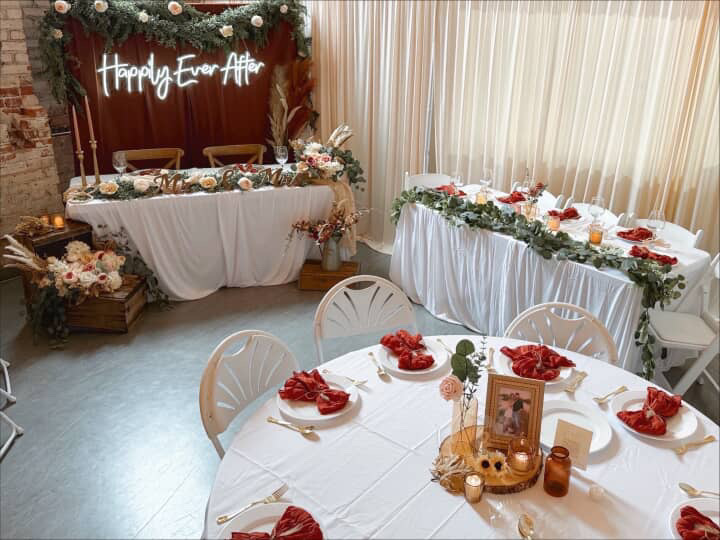 Wedding reception with red napkins, gold flatware and the Happily Ever After neon backdrop at Host Wenatchee