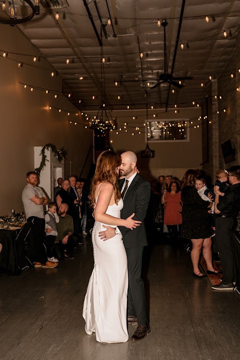 Bride and groom first dance under string lights at their Wenatchee wedding reception