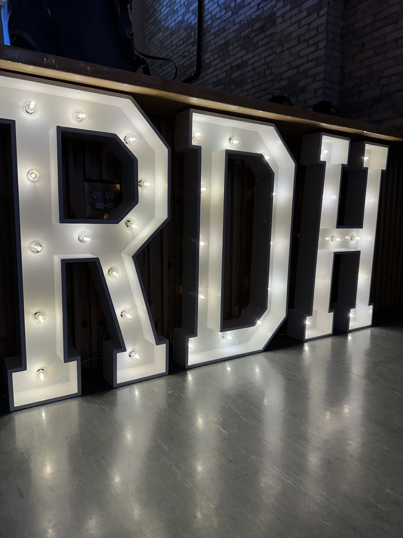 Light-up marquee letters glowing in front of the bar at a graduation celebration at Host Wenatchee