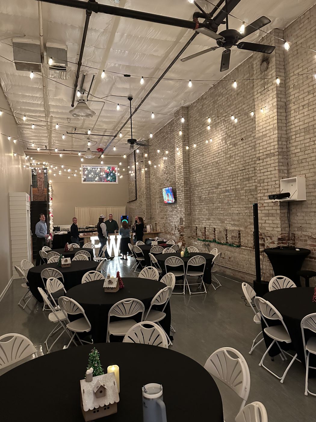 Exposed brick wall and string lights in the Host Wenatchee event space