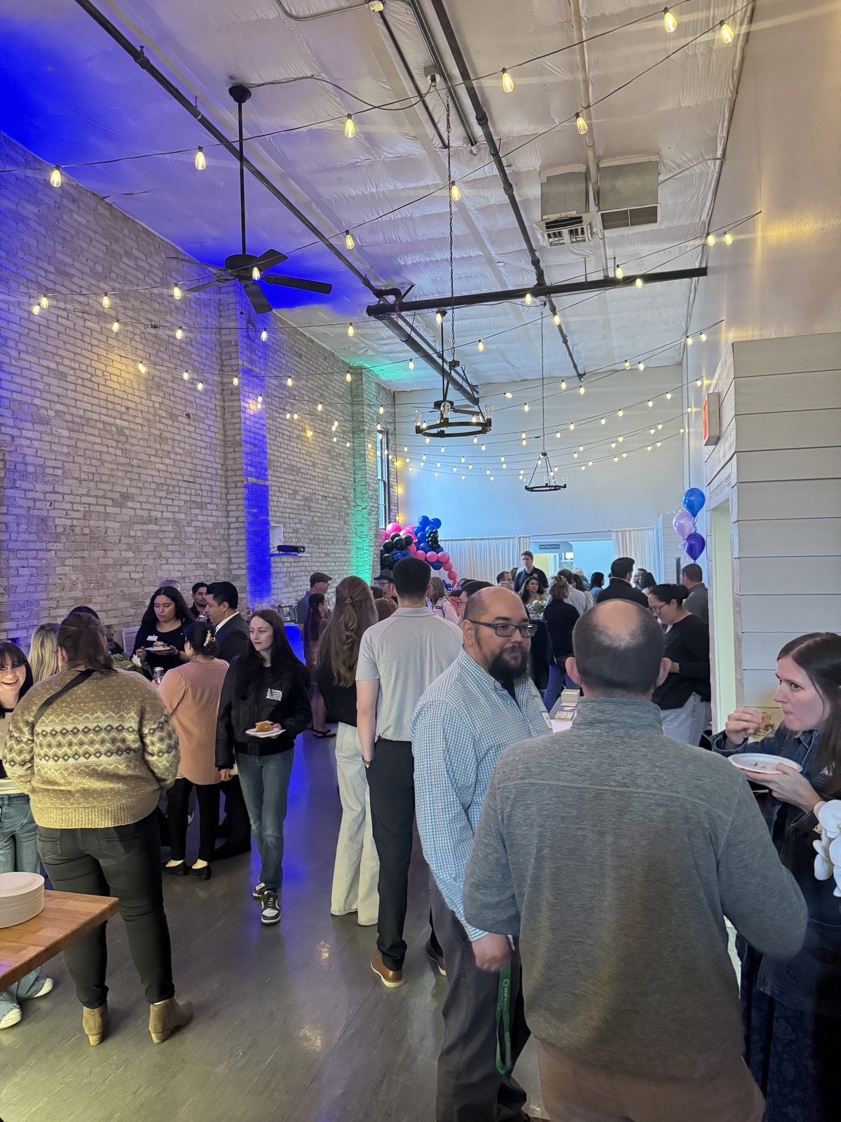 Guests networking with appetizers under string lights at a business mixer at Host Wenatchee