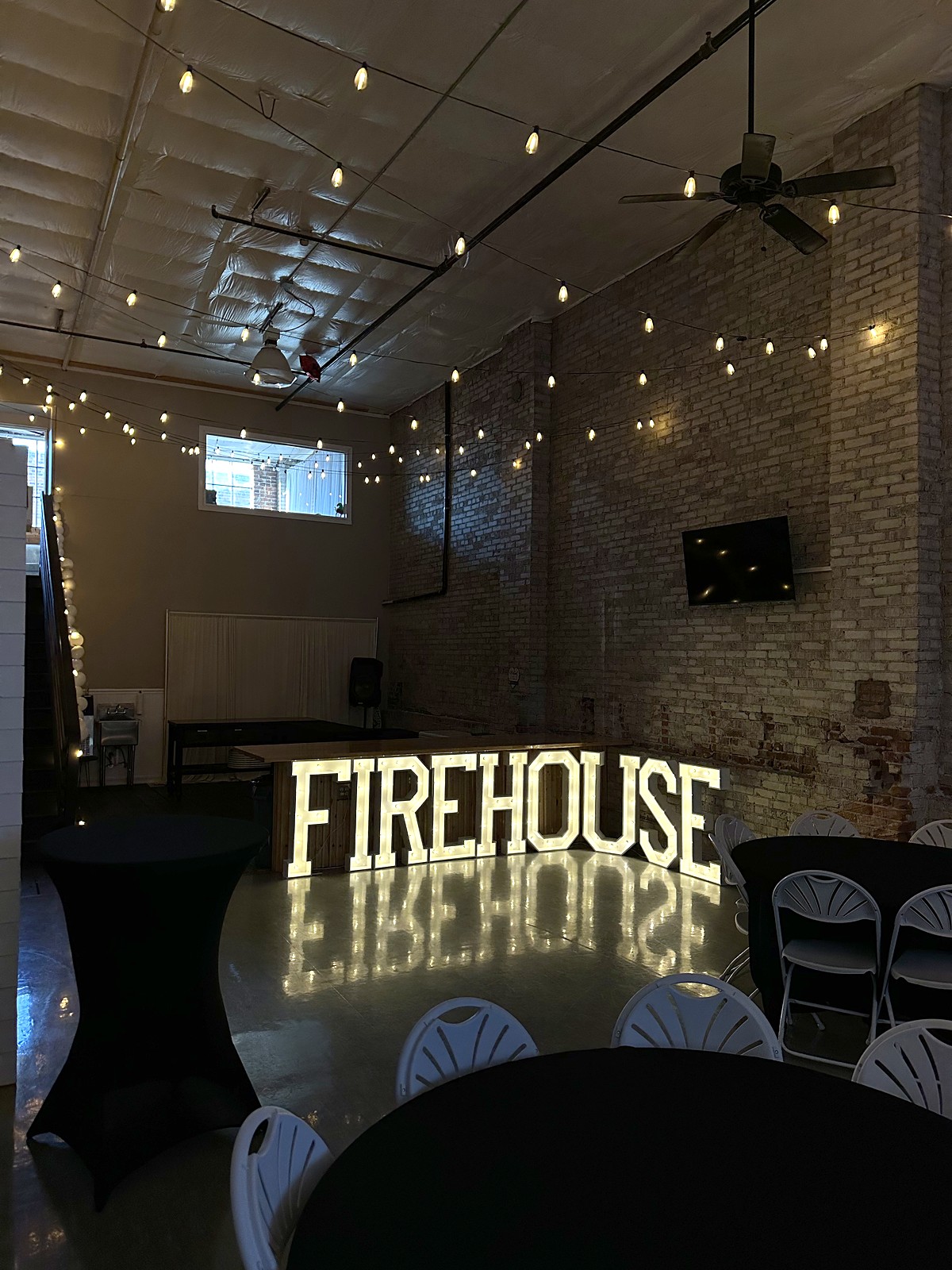 Cocktail tables and glowing marquee letters at a holiday event