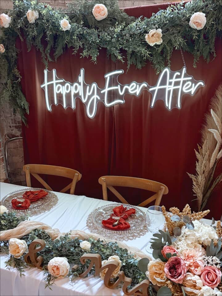 Happily Ever After neon sign over a garland-draped sweetheart table at Host Wenatchee