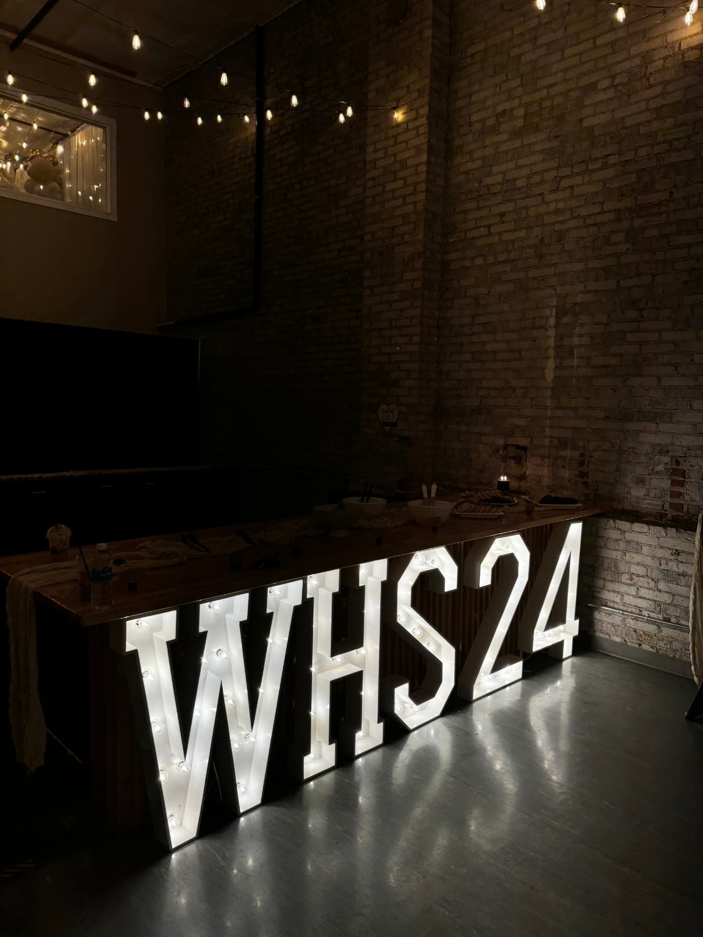Light-up WHS24 marquee letters in front of the wood buffet counter at Host Wenatchee