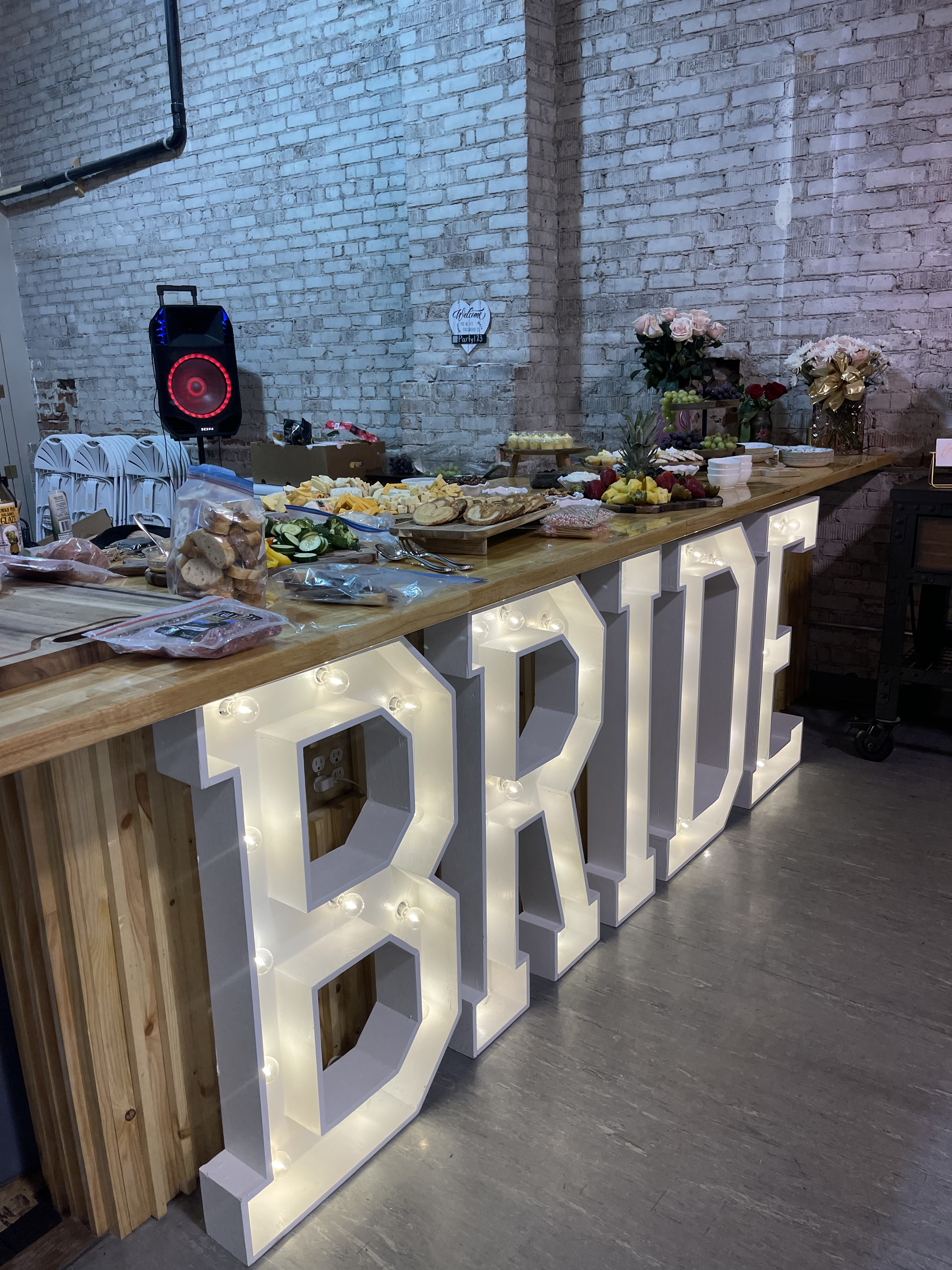 Light-up BRIDE marquee letters beside a bridal shower charcuterie and dessert bar at Host Wenatchee