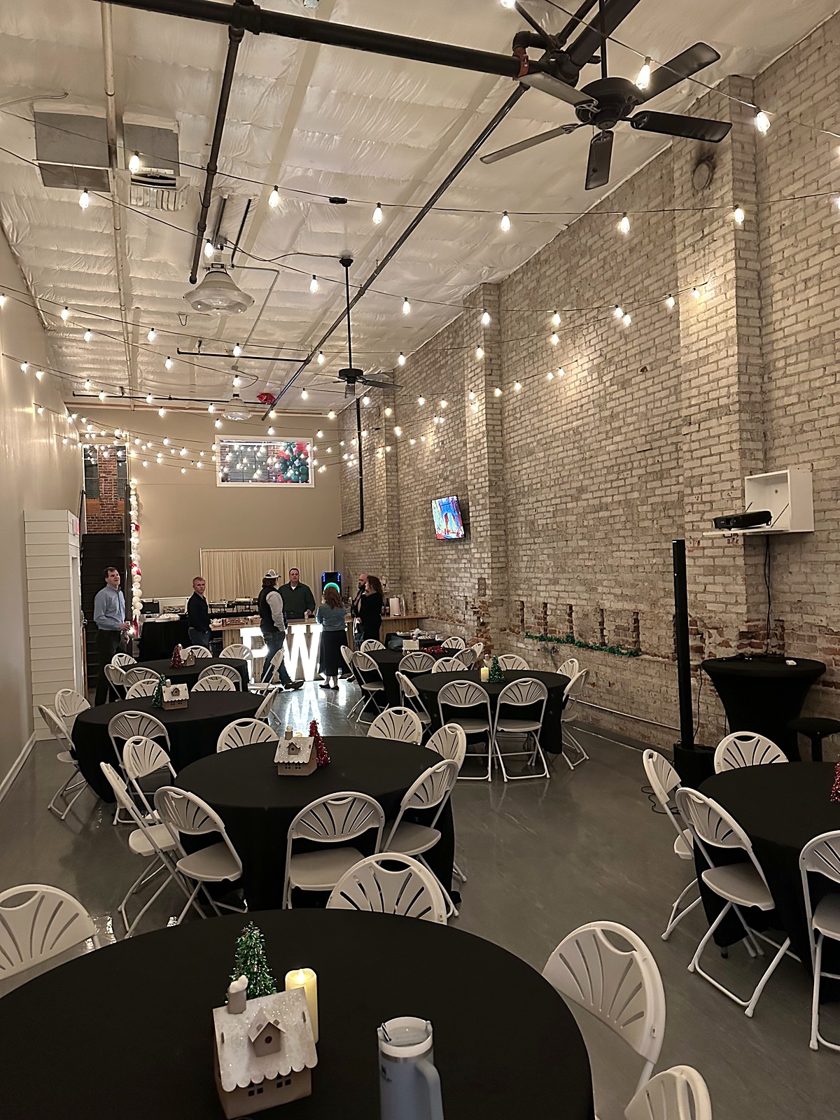 Holiday party tables and chairs set under string lights at Host Wenatchee
