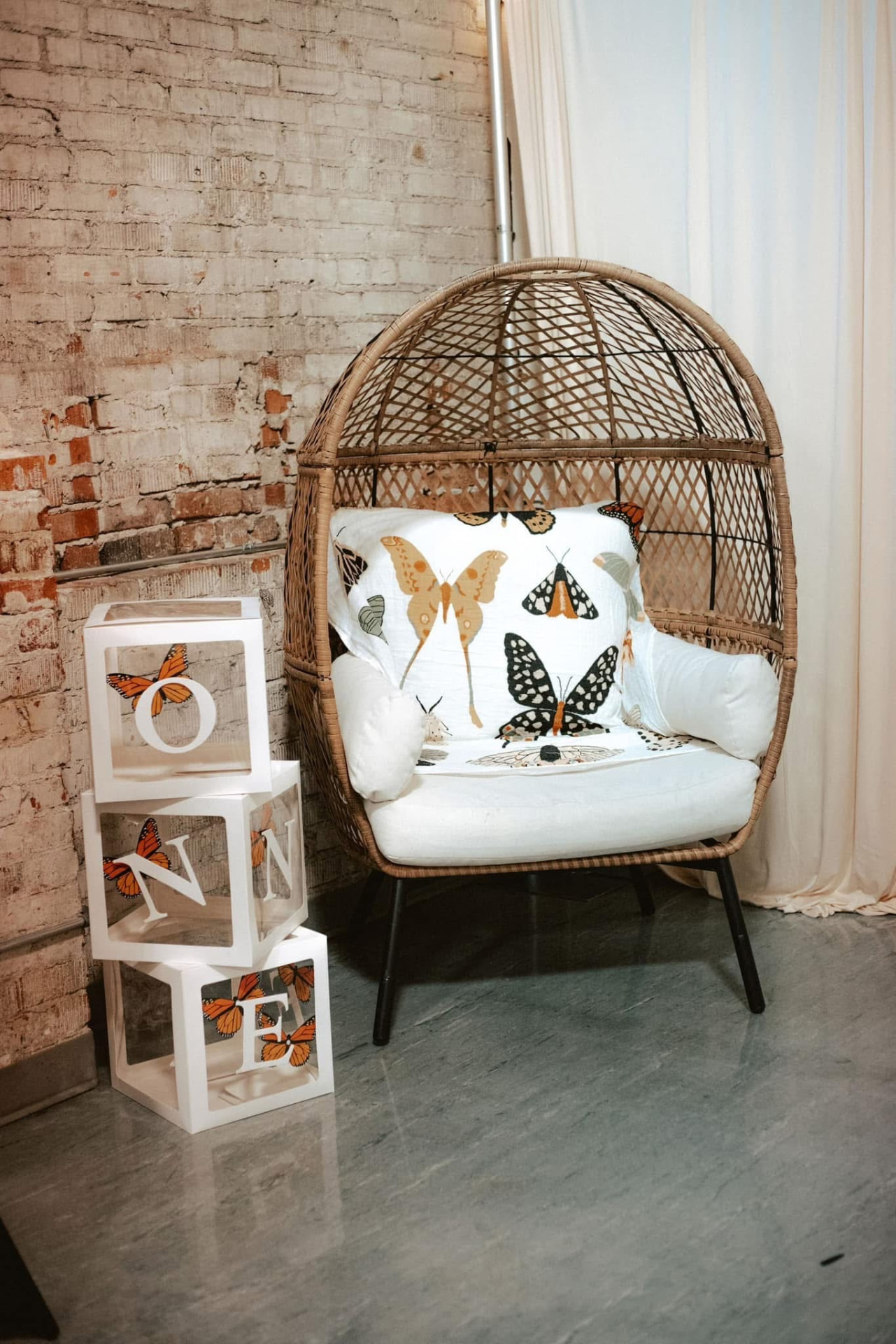 Wicker egg chair photo corner with ONE balloon blocks for a first birthday