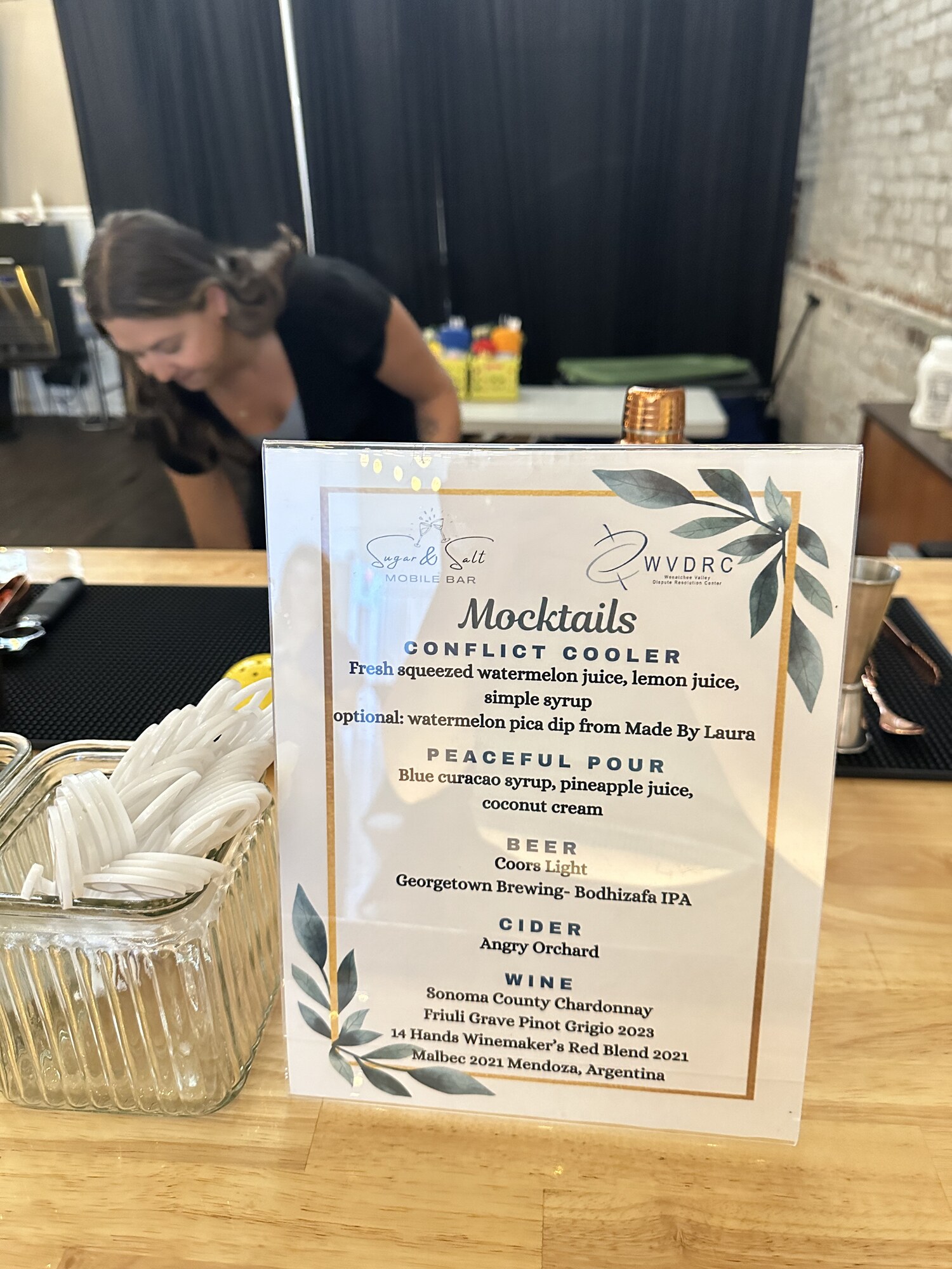 Mocktail menu on the bar with a bartender mixing drinks at a corporate event at Host Wenatchee