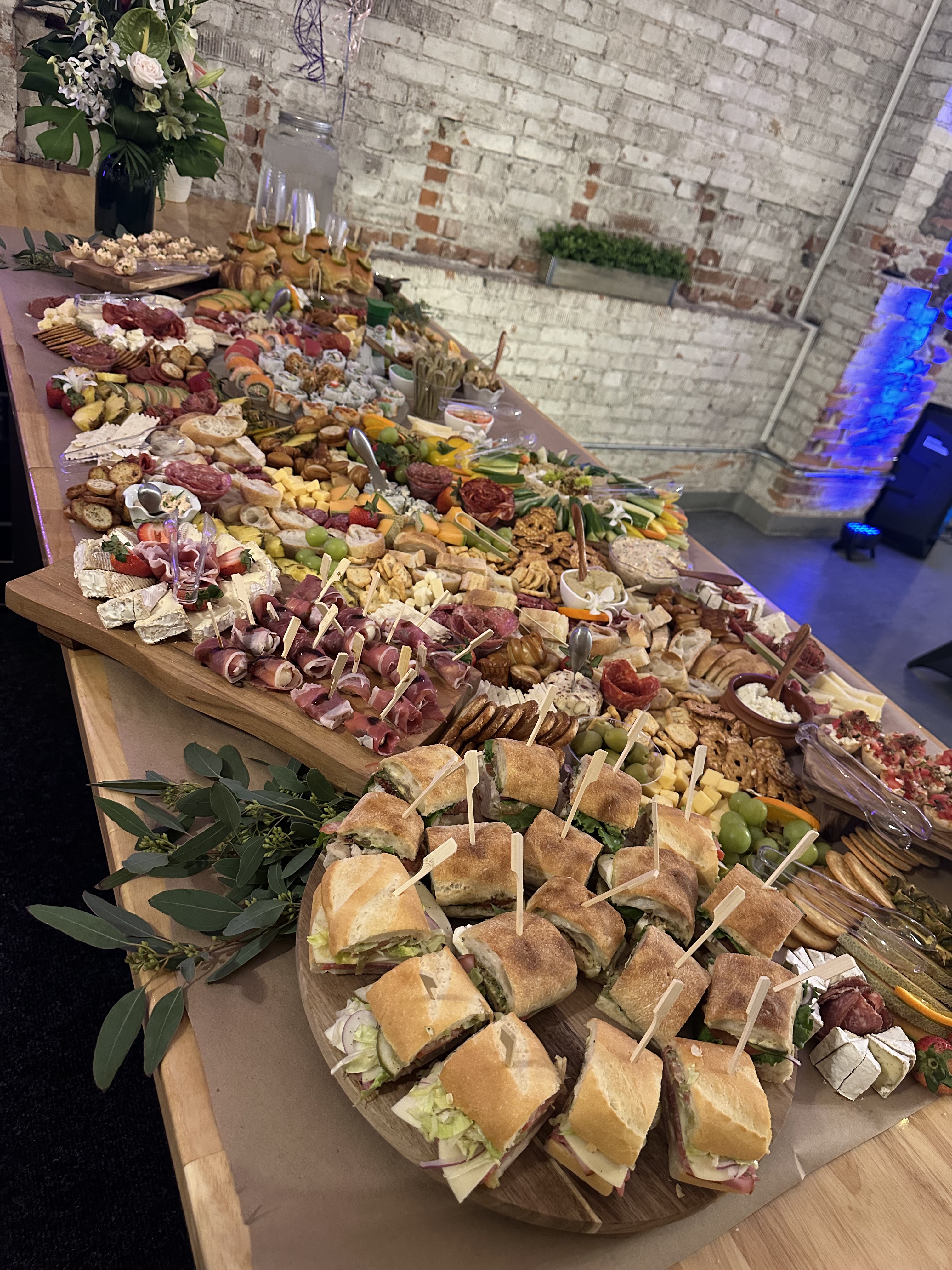 Large grazing table with charcuterie and sandwiches at a community event at Host Wenatchee