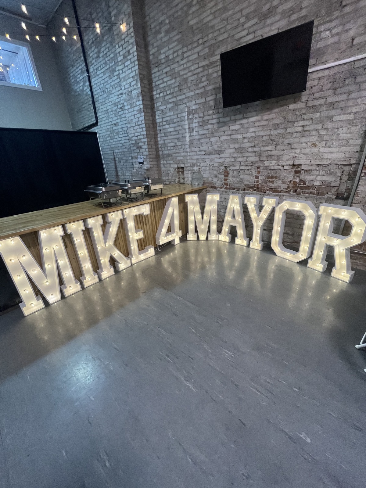 Light-up MIKE 4 MAYOR marquee letters and catering buffet at a corporate event in downtown Wenatchee