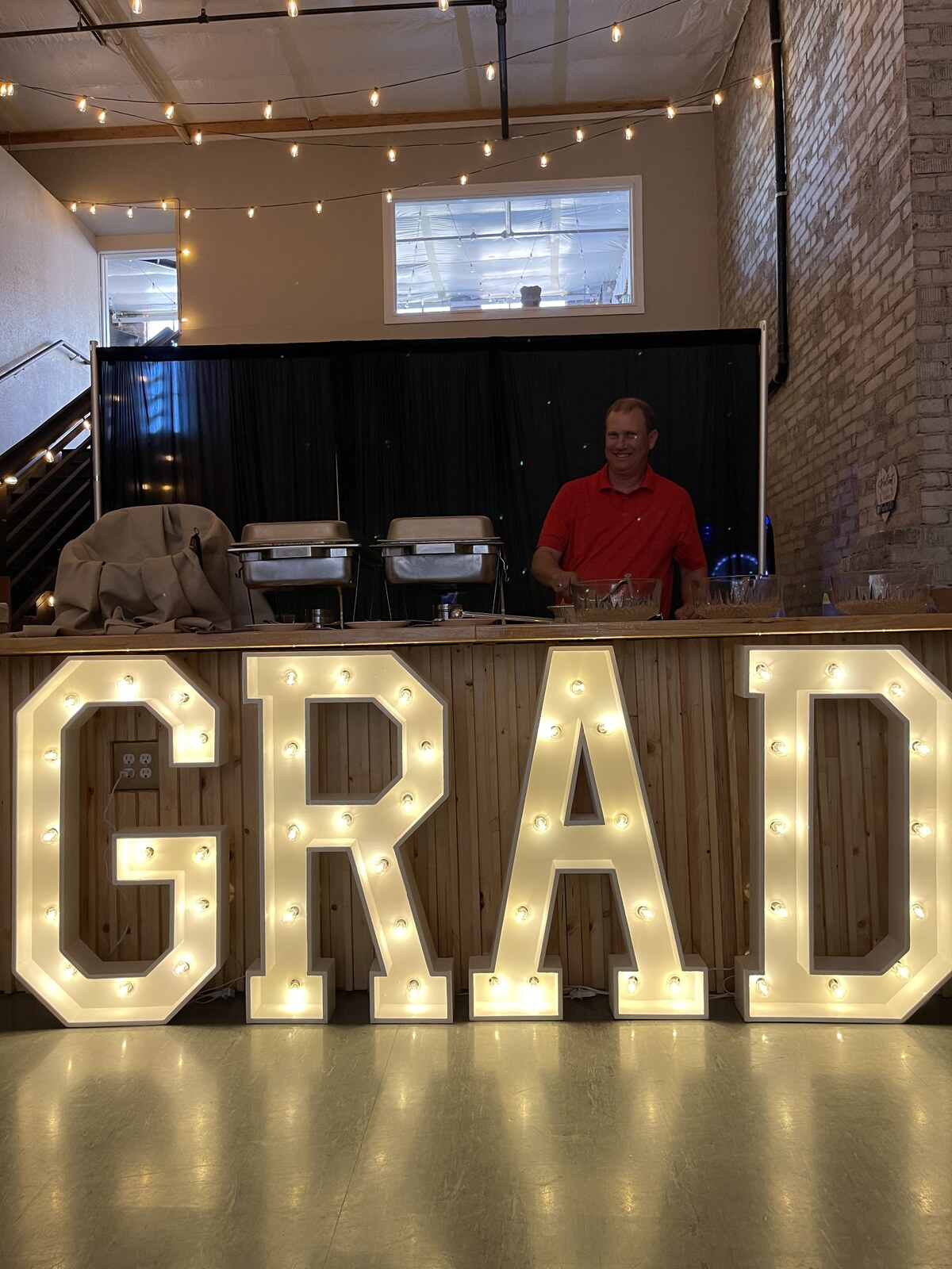 Light-up GRAD marquee letters in front of the buffet counter at a graduation party at Host Wenatchee
