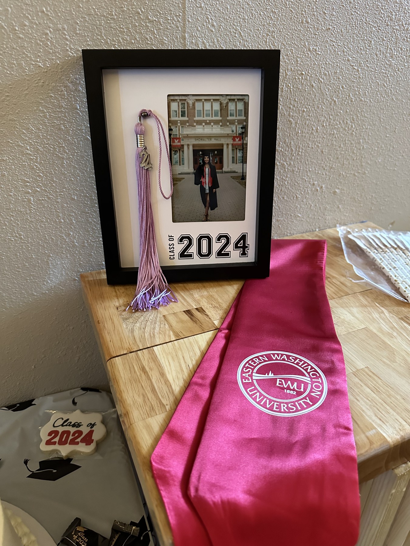 Class of 2024 shadow box with tassel and Eastern Washington University sash on the grad memory table at Host Wenatchee